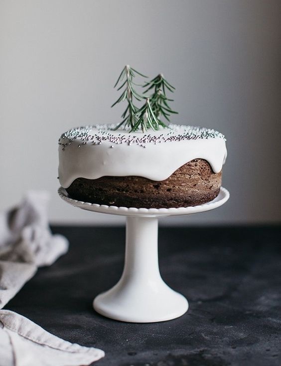 Christmas cake minimalistic decoration with rosemary trees as cake toppers