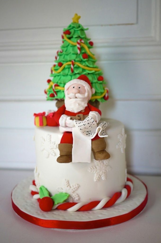 A sitting Santa Claus with a Christmas tree as a cute cake topper