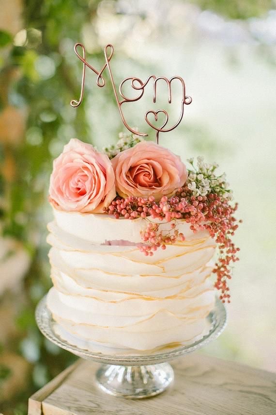 A wire cake topper that reads 'MOM'
